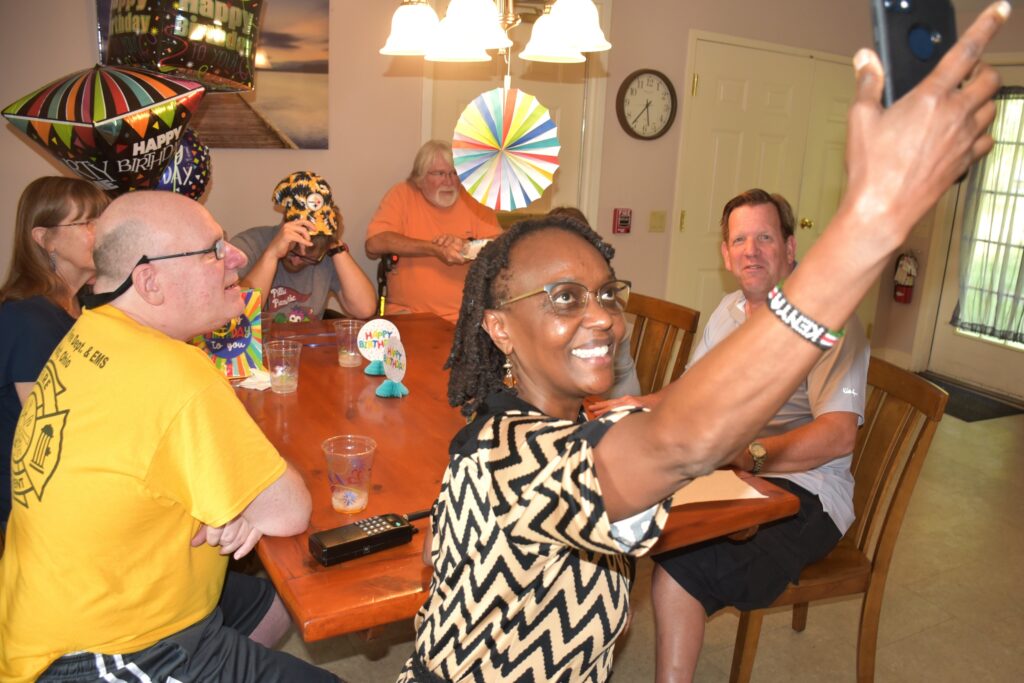 woman takes selfie with group at birthday party