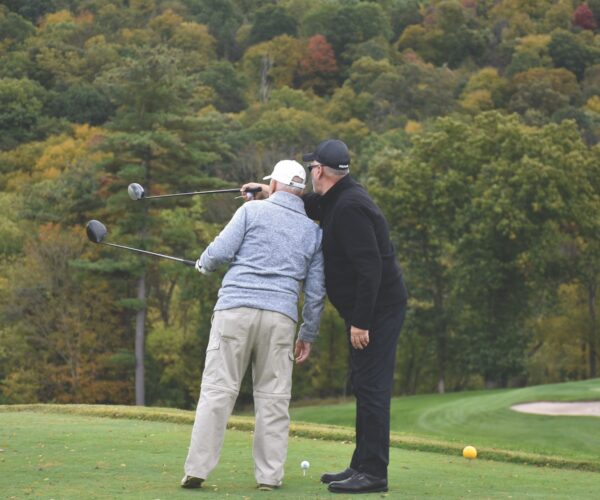 two golfers on pointing with golf clubs