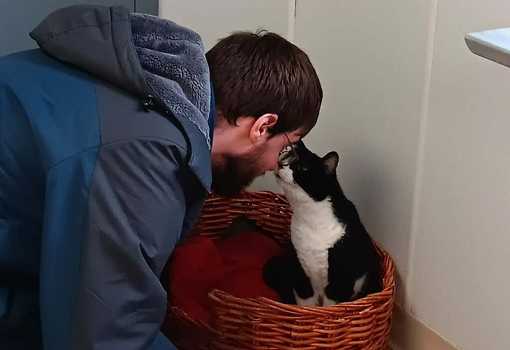 a UCP program participant interacts with a black and white cat