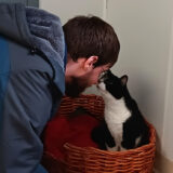 a UCP program participant interacts with a black and white cat