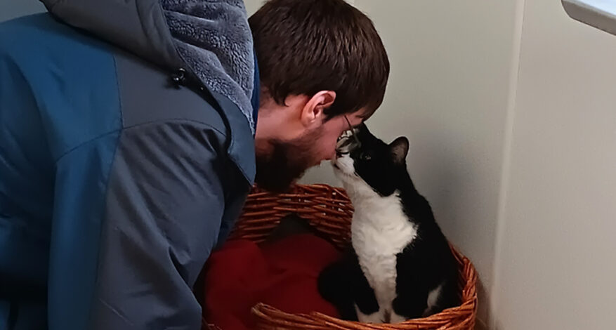 a UCP program participant interacts with a black and white cat